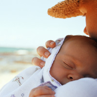 Mom holding baby on the beach