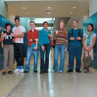 Teenagers standing in school hall in between lockers