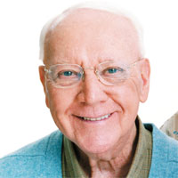 Older gentleman with white hair and glasses, smiling