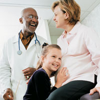 Girl listening to mom's pregnant belly at doctor's office