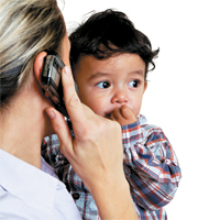 Woman on cell phone, holding child