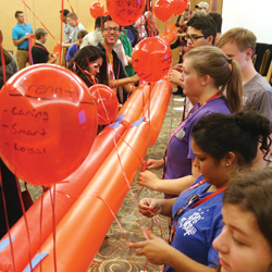 Teenagers engaged in problem-solving exercise with balloons