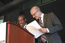 Val Bias and John Indence standing at podium