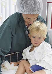 Mother comforting son in hospital bed