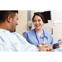 Nurse speaks to patient in hospital bed