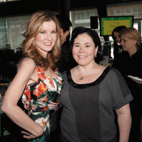 Woman in floral dress and woman in grey top standing together