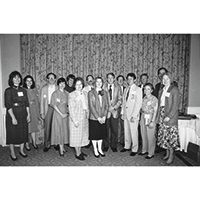 group of people standing in front of a curtain