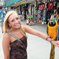 Kali Woldt with colorful parrot on her arm