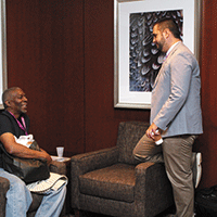 An Atlanta Summit attendee sits and chats with Jonathan Roberts, MD
