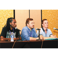 Three male panelists sitting in front of microphones