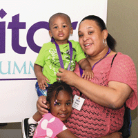 Woman hugged by toddler and young girl