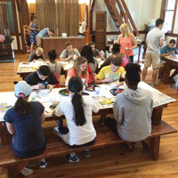 teenagers sitting at table during art workshop