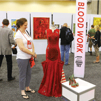 Woman admiring hemophilia inspired red ballgown on display