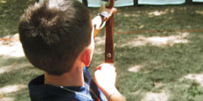 Boy with hemophilia shooting arrow in archery