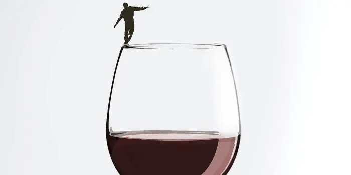 Illustration of small person balancing on the rim of a wine glass.