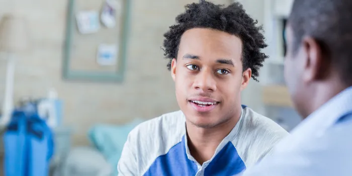 Serious African American teenager has conversation with his dad