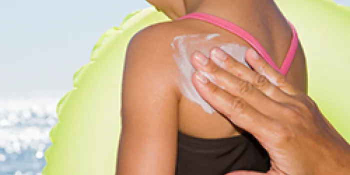 Parent applies sunscreen on toddler