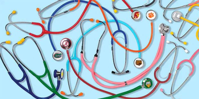 A pile of stethoscopes, each a different color and branded with a college logo 