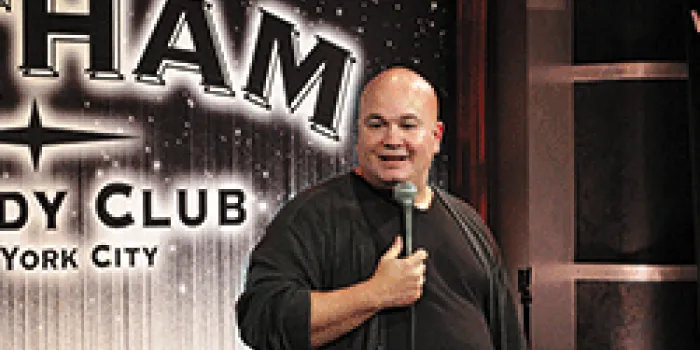 Comedian with microphone onstage at Gotham Comedy Club