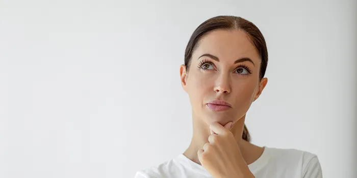 A puzzled woman thinking with her hand on her chin