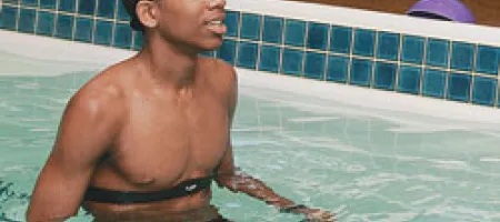 Boy with hemophilia exercises in a pool