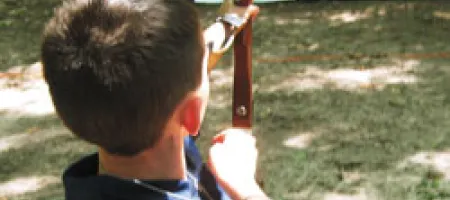 Boy with hemophilia shooting arrow in archery