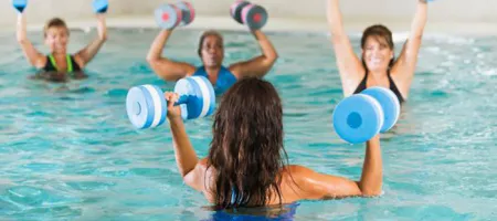 A group of women exercising in an indoor swimming pool