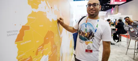 Man stands in front of world map at World Federation of Hemophilia World Congress 
