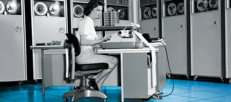 Black and white photo of woman typing on a typewriter.