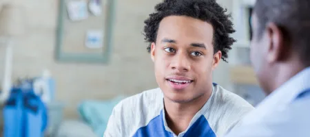 Serious African American teenager has conversation with his dad