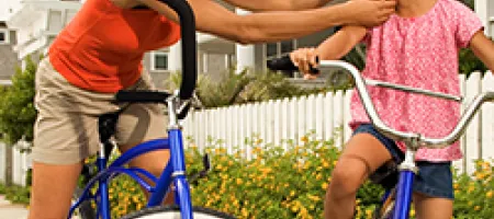 Mother and child putting on bike helmets.