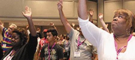 Inhibitor Summit participants with hands raised in air