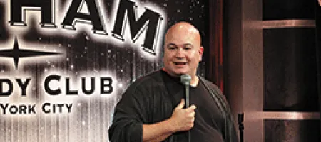 Comedian with microphone onstage at Gotham Comedy Club