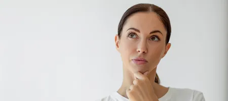 A puzzled woman thinking with her hand on her chin