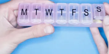 Hands holding weekly pill container