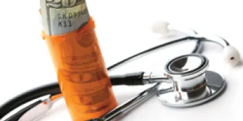 Twenty dollar bill rolled in prescription bottle next to stethoscope